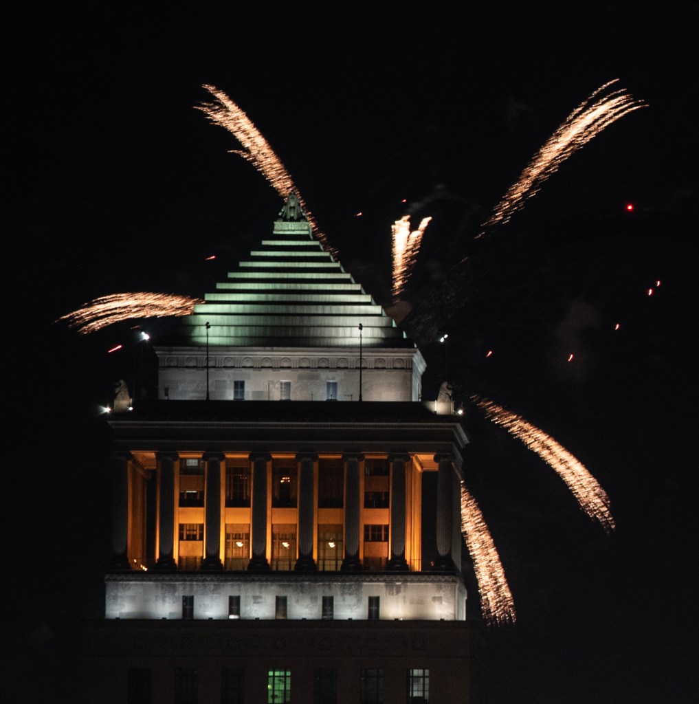 Fireworks erupting above a historic building at night, celebrating a festive occasion.