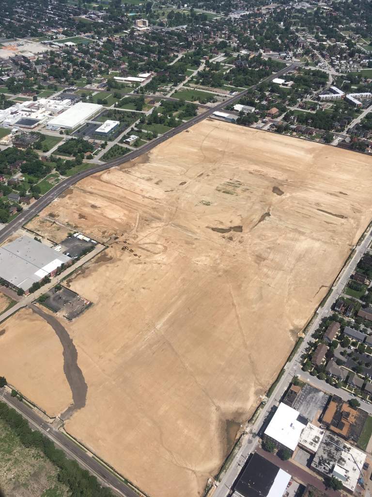 Aerial view of a large, cleared plot of land in St. Louis, indicating a development area with roads and neighboring buildings visible.