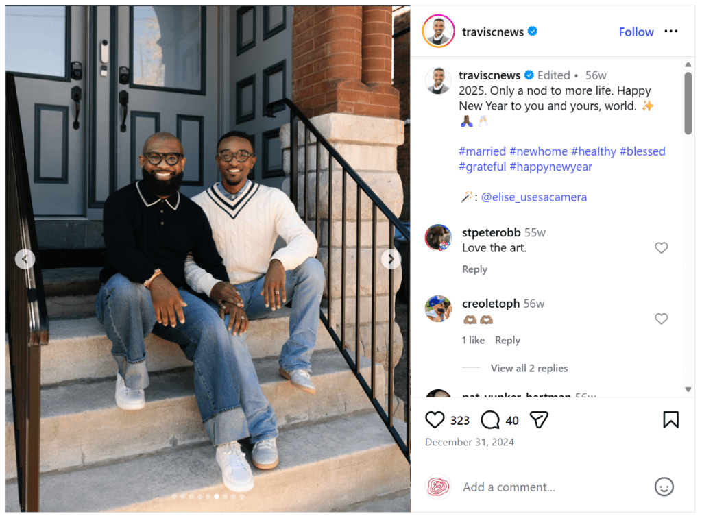 Two men sitting on the steps of a house, smiling at the camera. One is wearing a black shirt with a collar, while the other is dressed in a white sweater with a v-neck and a patterned design.