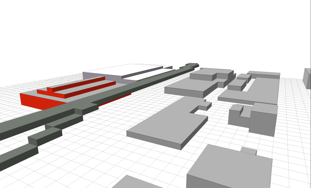 3D model depicting a layout of rectangular structures with varying heights, including a prominent red building and a linear gray feature, set against a white background with a grid pattern.