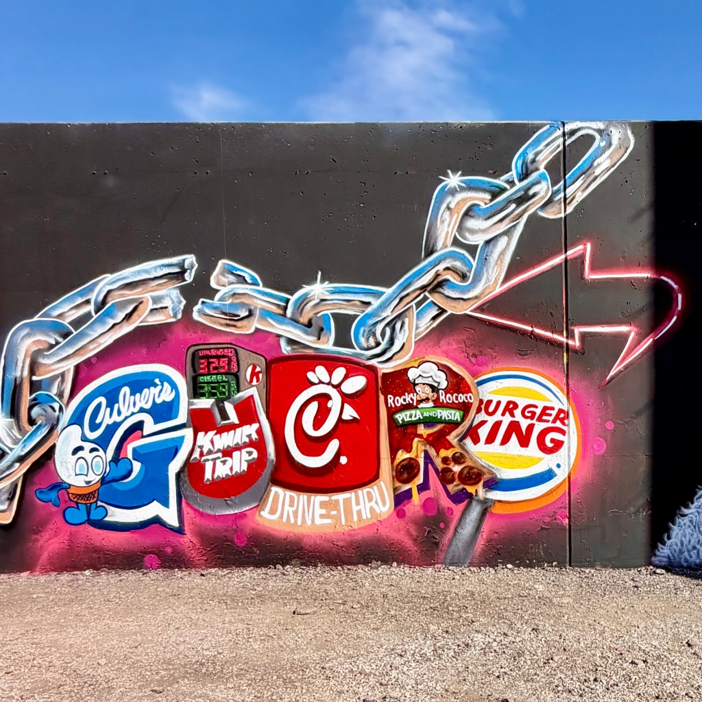 Colorful mural featuring logos of fast food restaurants including Culver's, Chick-fil-A, Rocky & Rocco's, and Burger King, surrounded by a chain design.